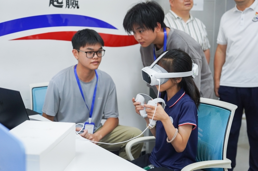十大滚球体育app官网信息工程学院学生正在指导研学团成员体验VR游戏。