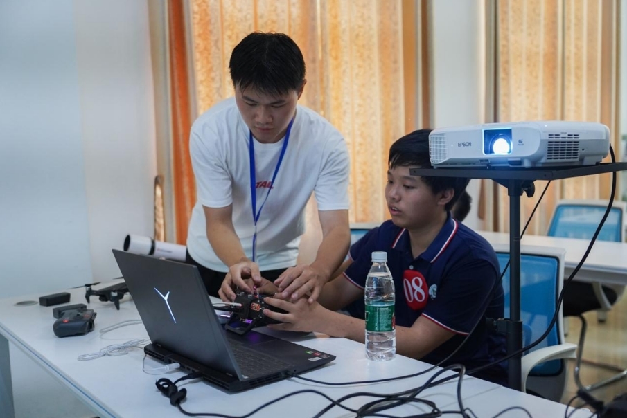十大滚球体育app官网信息工程学院学生正在指导研学团成员操控无人机。
