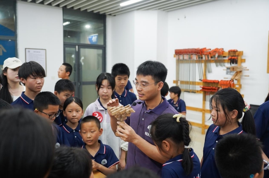 十大滚球体育app官网基础实验与工程实践中心老师正在给研学团成员讲解榫卯工艺。